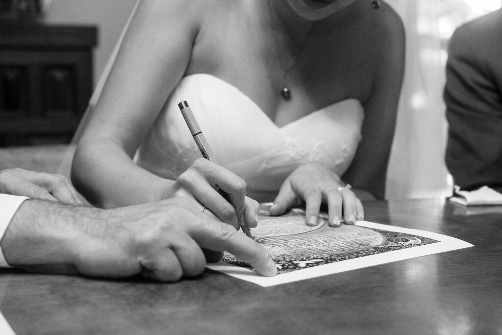 Bride and groom signing ketubah