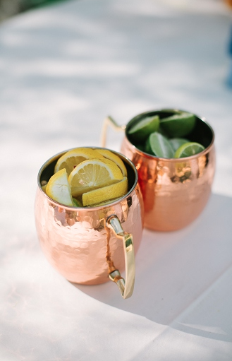 Copper mugs for moscow mules with lemon and lime garnish