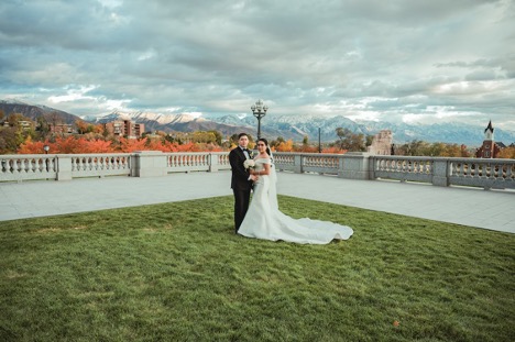 Bride and groom taking photos with mountain backdrop
