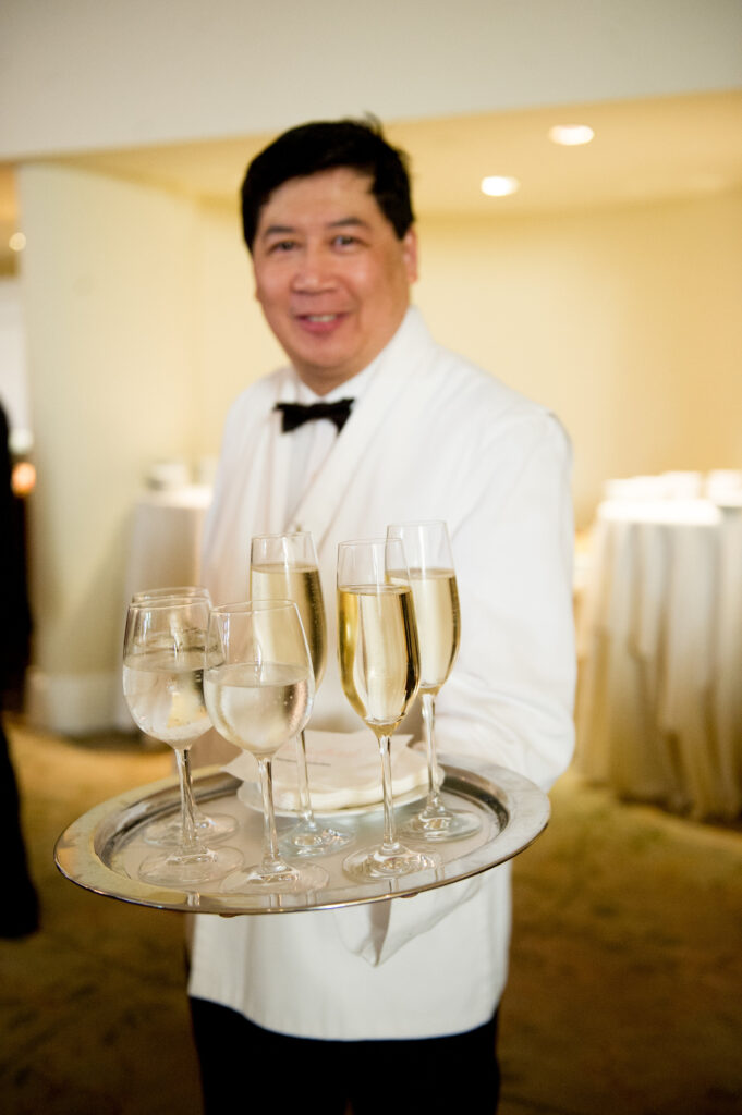 Waiter in tuxedo holding tray of champagne